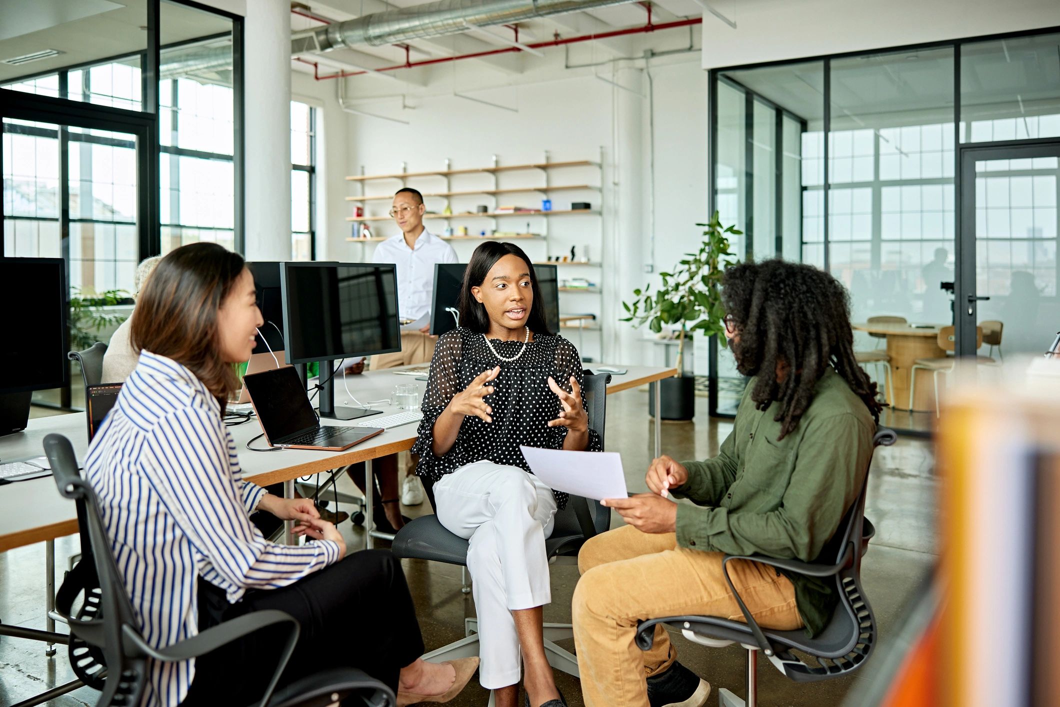 Three colleagues exchanging ideas in a modern office